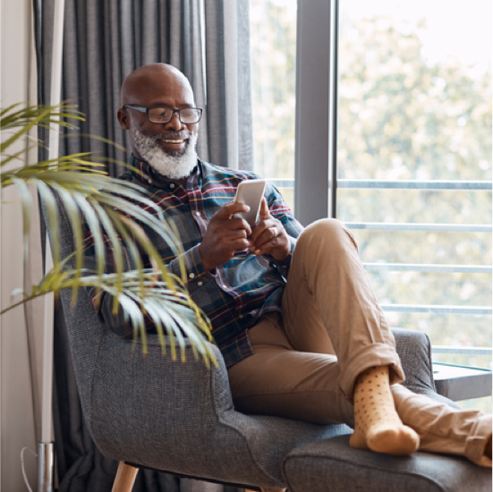 elderly man smiling viewing his mobile phone