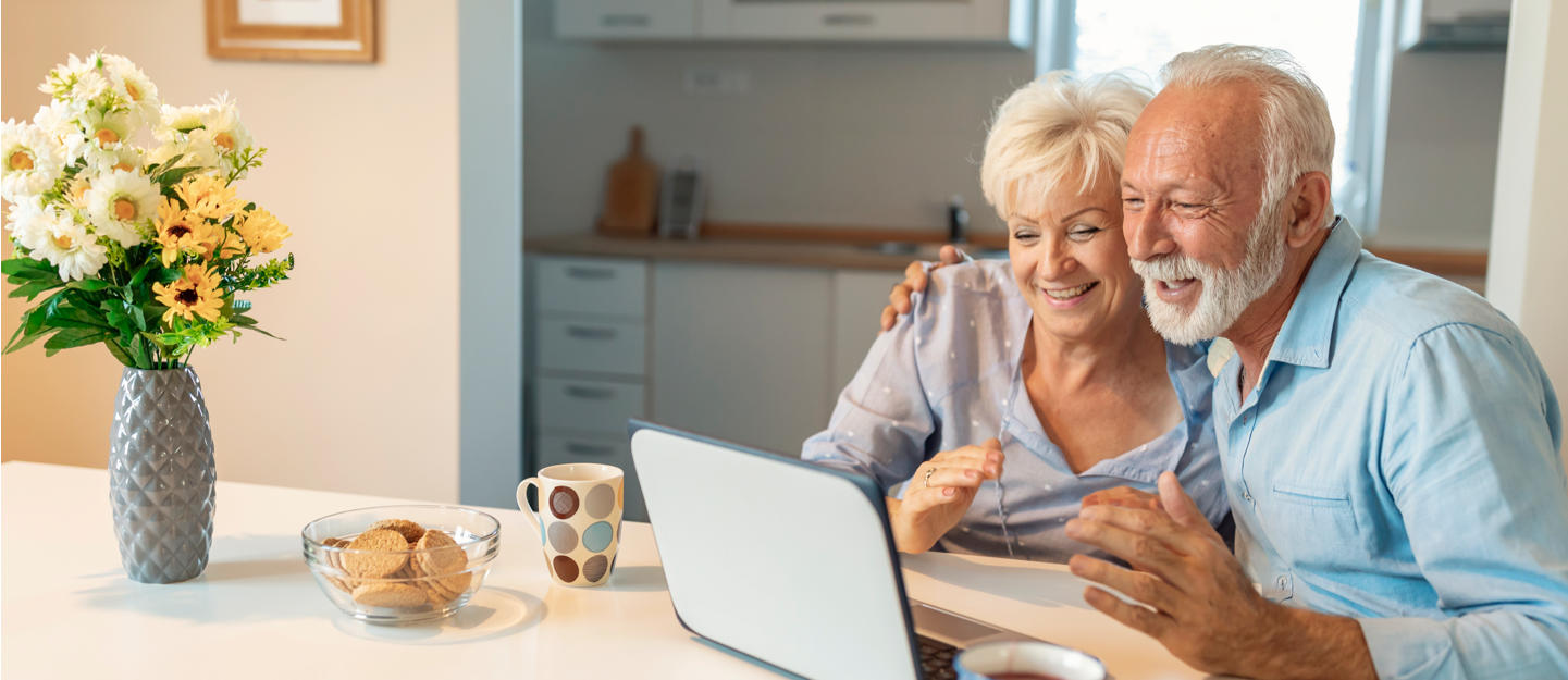 elderly couple viewing their laptop